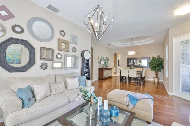 a living room with furniture a fireplace and a chandelier