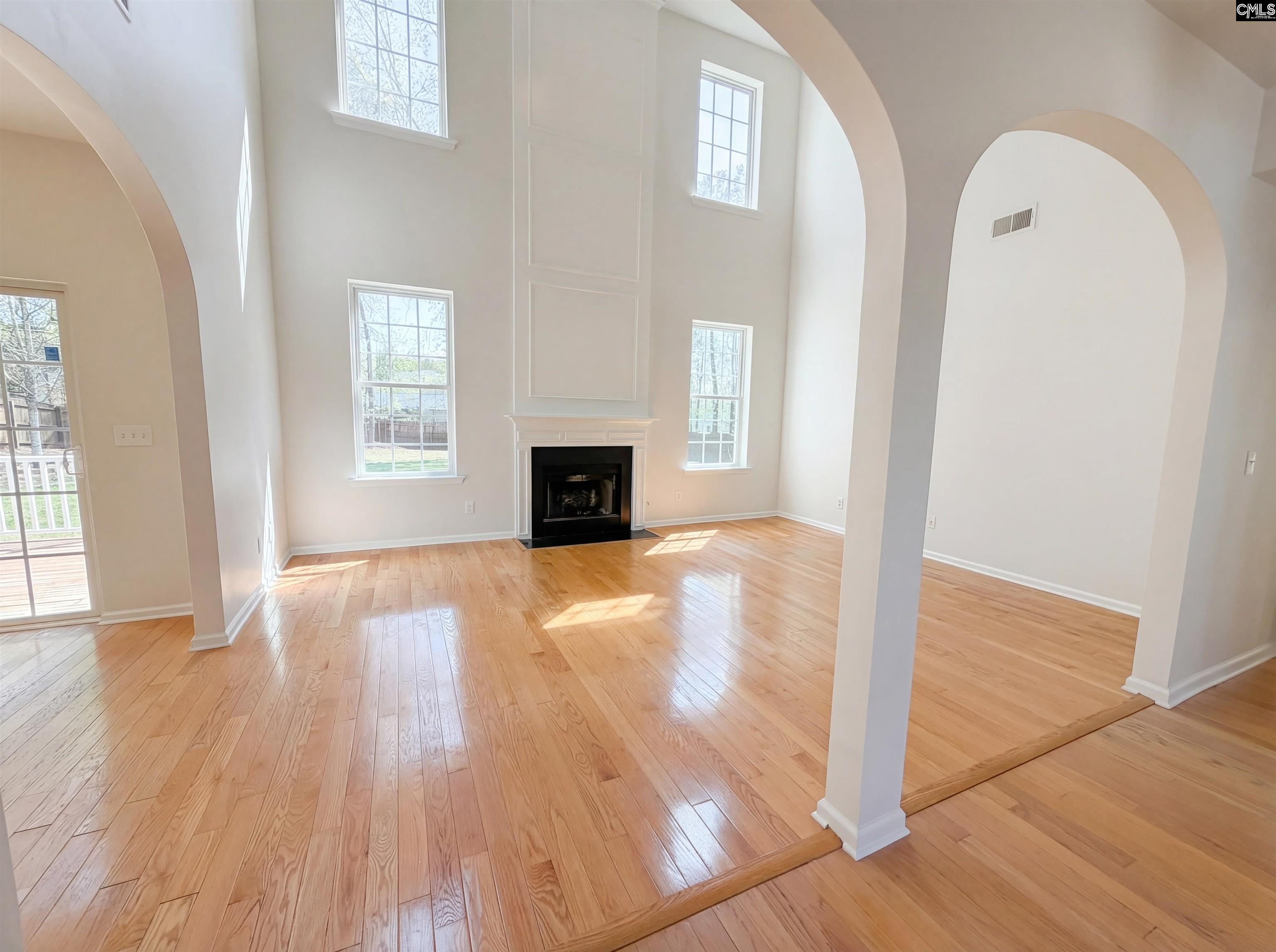 112 Coopers Hawk Circle Irmo, SC 29063 - Photo 3 of 26 an empty room with wooden floor a fireplace and windows