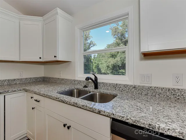 an empty room with wooden floor a ceiling fan and windows