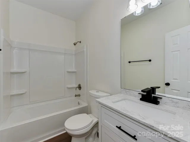 an empty room with wooden floor ceiling fan and windows
