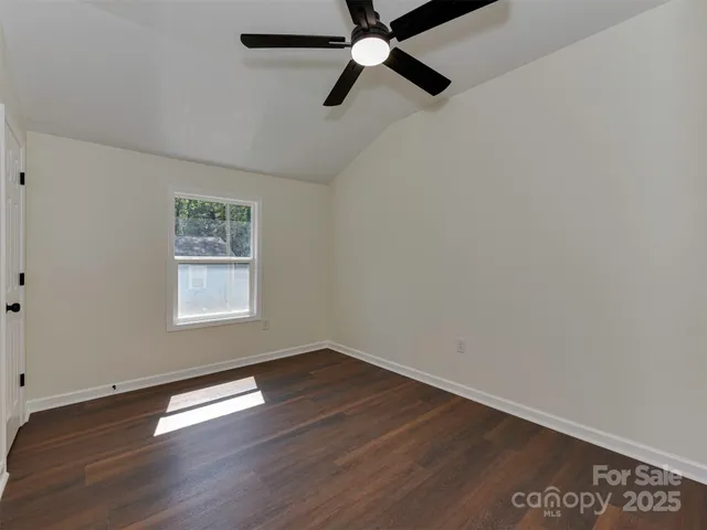 a view of a room with wooden floor closet and windows