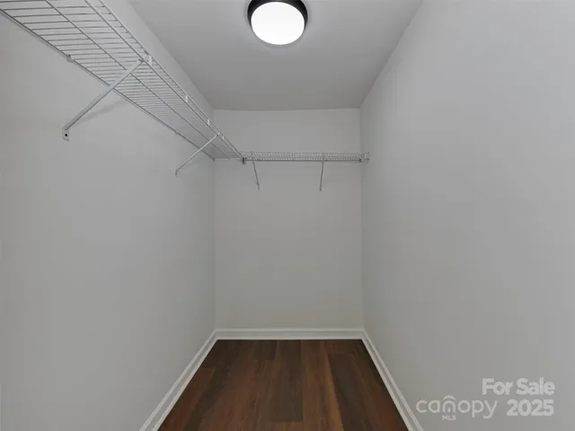 an empty room with wooden floor ceiling fan and windows