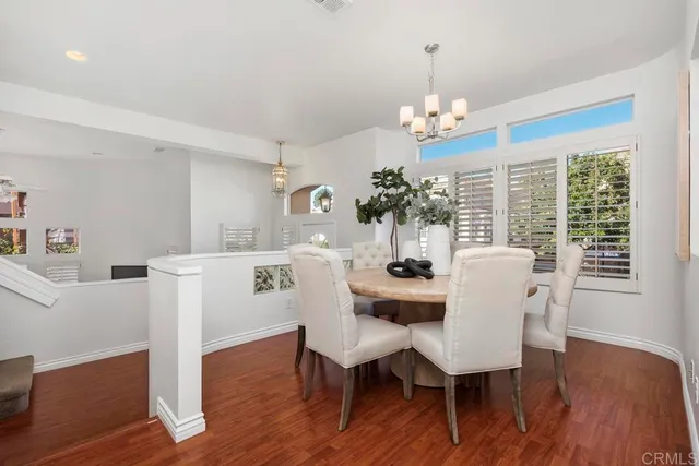 a spacious bedroom with a bed a chandelier and a mirror