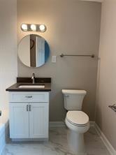 a bathroom with a toilet a sink and mirror