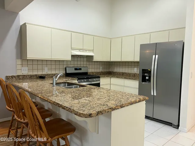 a kitchen with kitchen island a counter top space cabinets and a refrigerator