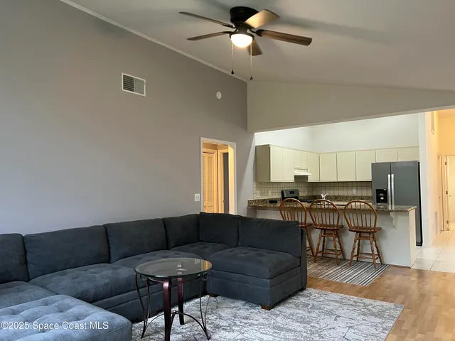 a living room with furniture and a dining table with kitchen view