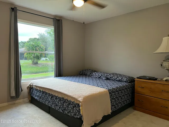 a bed sitting in a bedroom next to a window