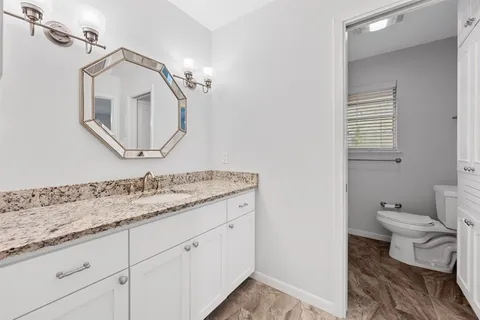 a bathroom with a toilet sink and mirror