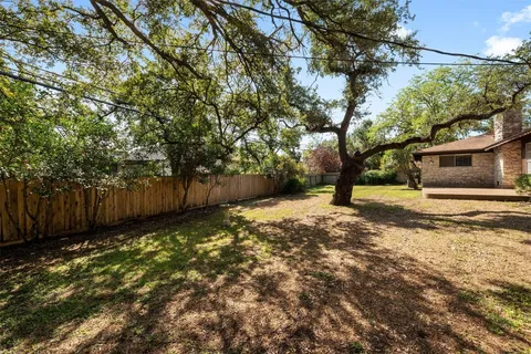 a view of a yard with wooden fence