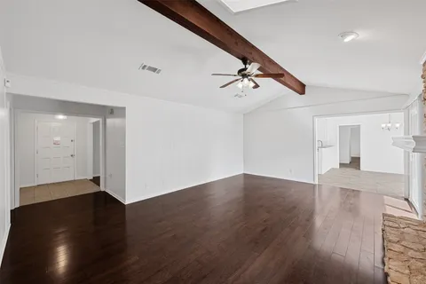 a view of an empty room with wooden floor