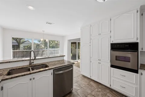 a kitchen with granite countertop a sink and a stove