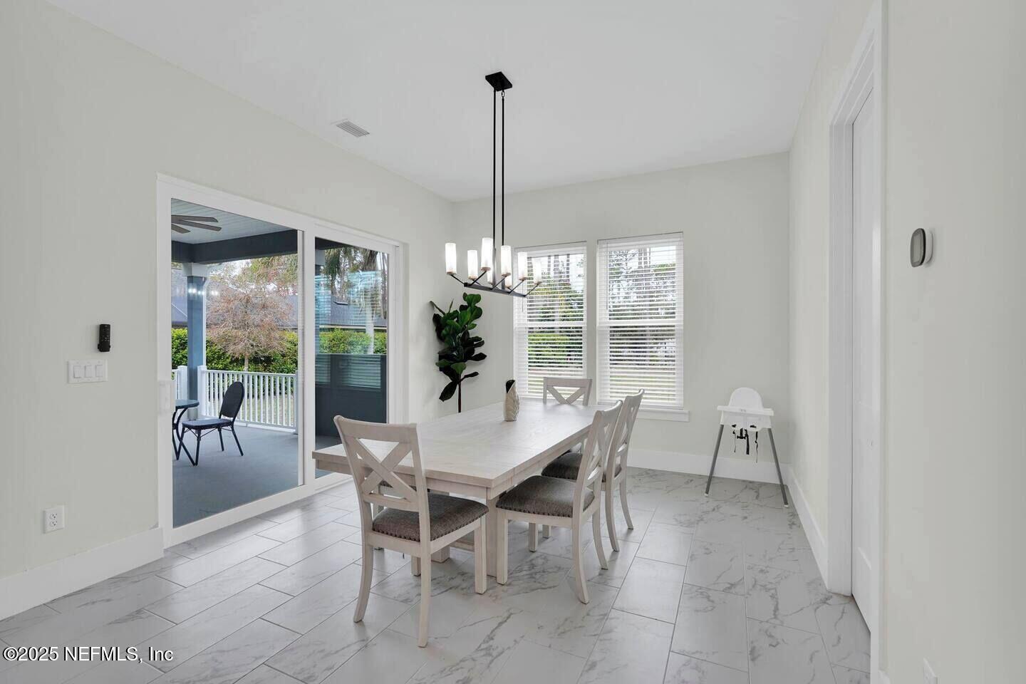 586 A1A North Ponte Vedra Beach, FL 32082 - Photo 12 of 29 a dining room with furniture large windows and a chandelier