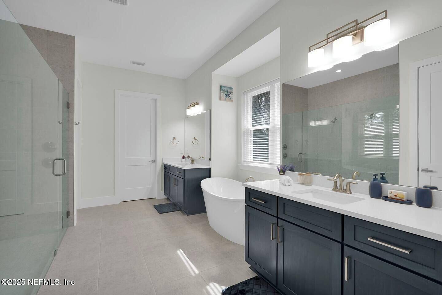 586 A1A North Ponte Vedra Beach, FL 32082 - Photo 17 of 29 a en suite bathroom with a double vanity sink a mirror and a shower