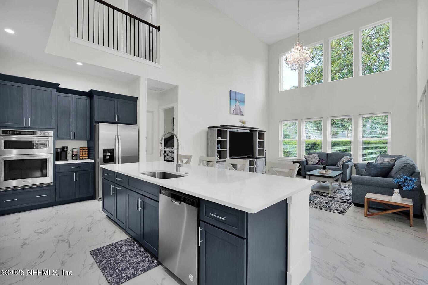 586 A1A North Ponte Vedra Beach, FL 32082 - Photo 9 of 29 a living room with stainless steel appliances kitchen island granite countertop a stove a sink dishwasher and a microwave oven with white cabinets