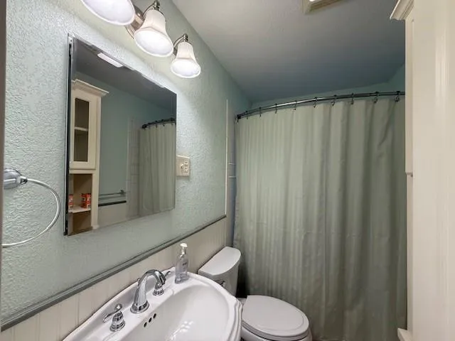 a bathroom with a sink a toilet and mirror