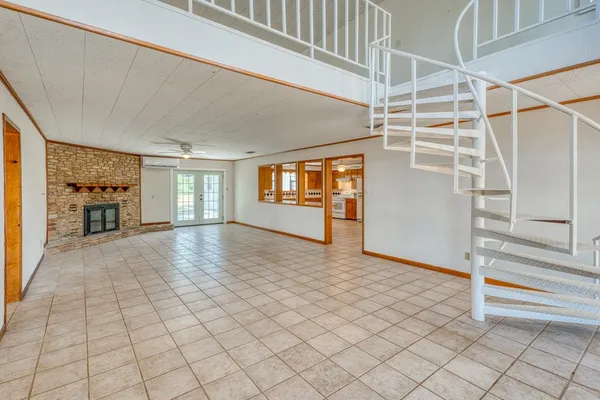 an empty room with windows and fireplace