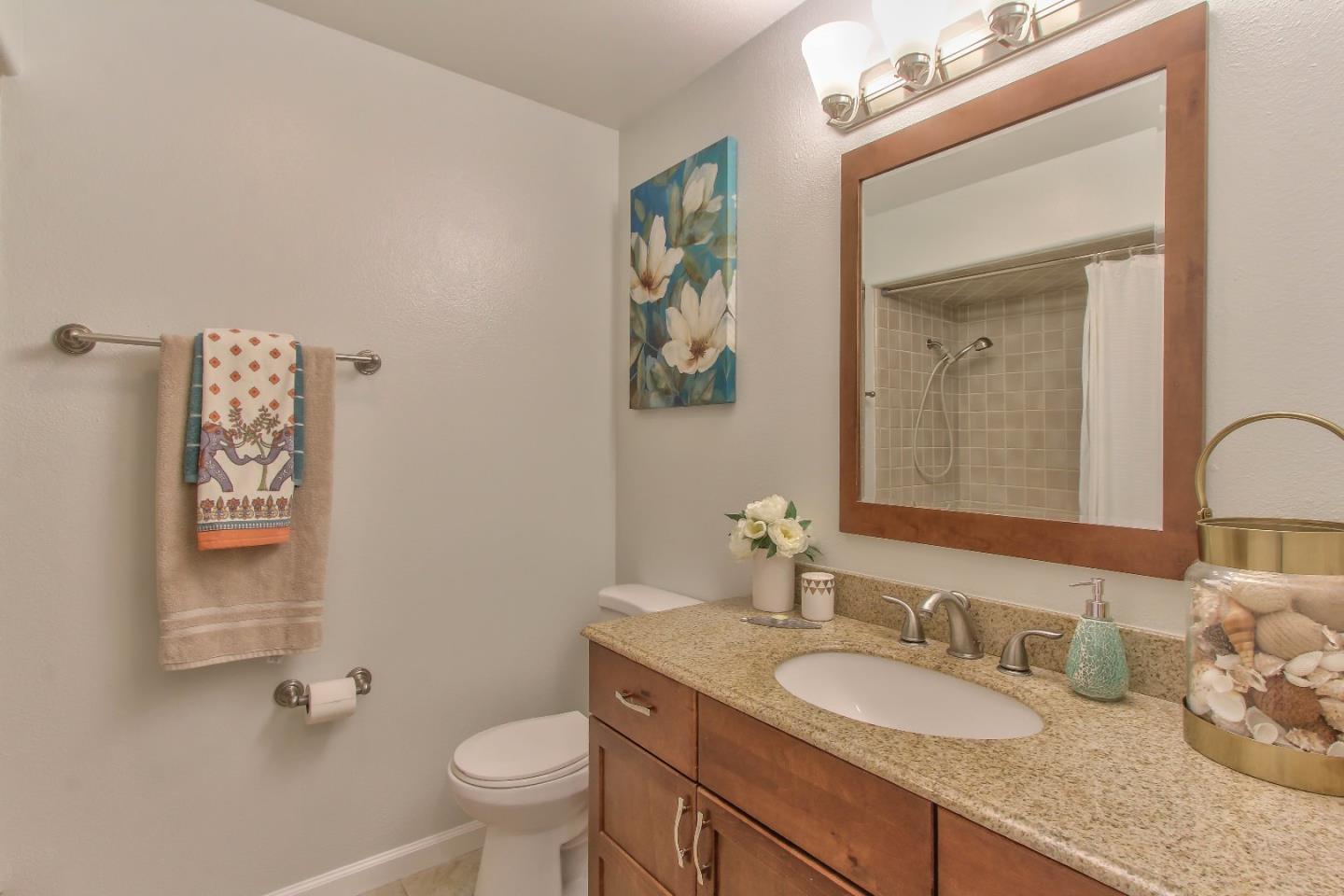 8623 Ormart Road Castroville, CA 95012 - Photo 15 of 34 a bathroom with a granite countertop sink a toilet and a mirror