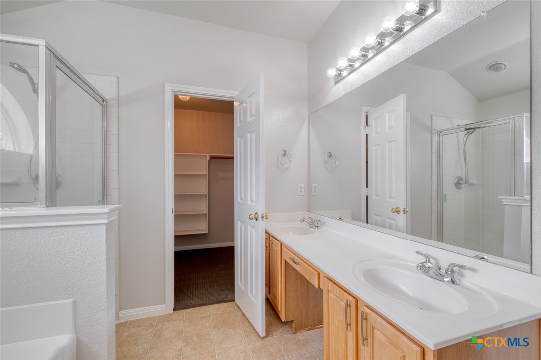 513 South Mockingbird Lane Lockhart, TX 78644 - Photo 16 of 25 a spacious bathroom with a double vanity sink a mirror and a shower