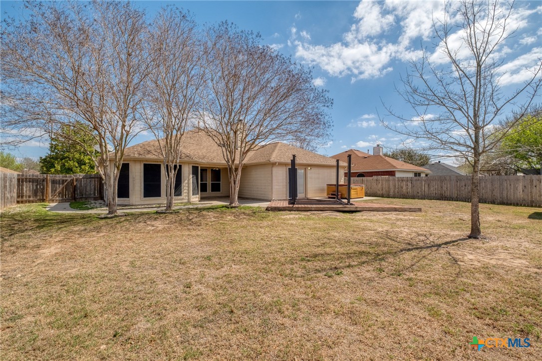 513 South Mockingbird Lane Lockhart, TX 78644 - Photo 23 of 25 a backyard of a house with large trees and outdoor seating