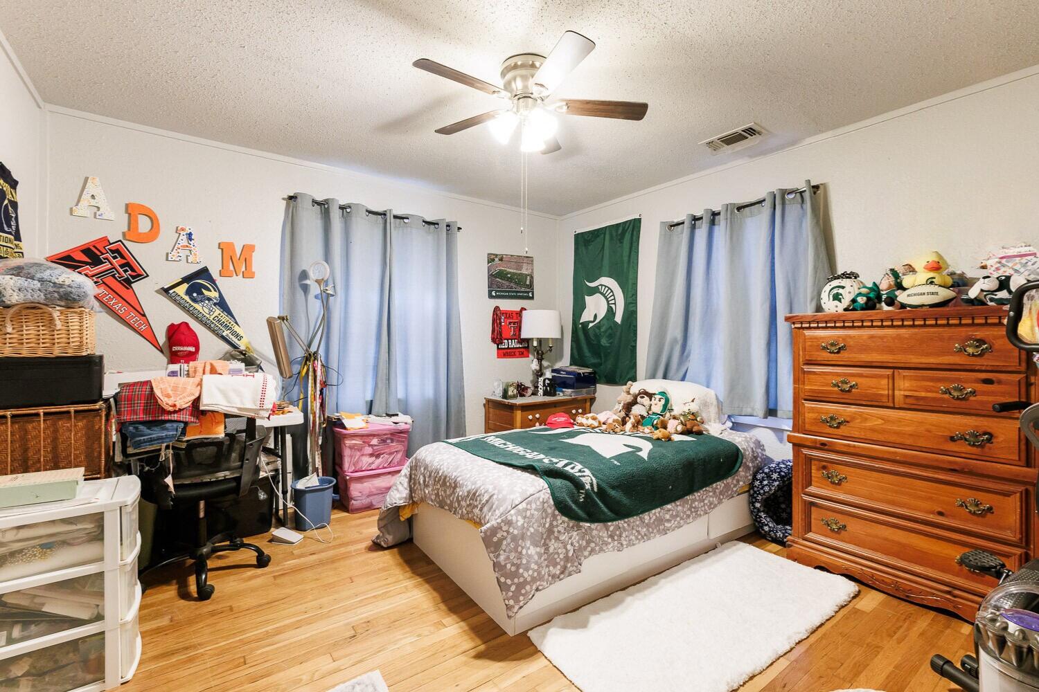 2004 26th Street Lubbock, TX 79411 - Photo 13 of 16 a bedroom with a bed and a chandelier