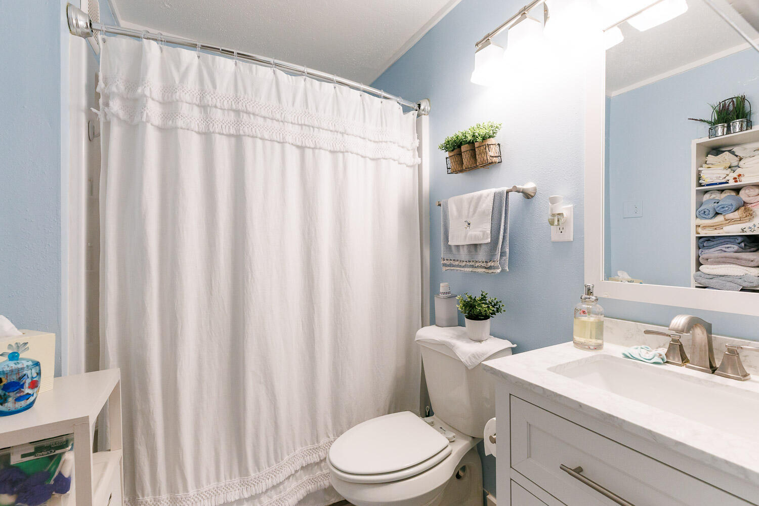 2004 26th Street Lubbock, TX 79411 - Photo 14 of 16 a bathroom with a sink a toilet and shower curtain