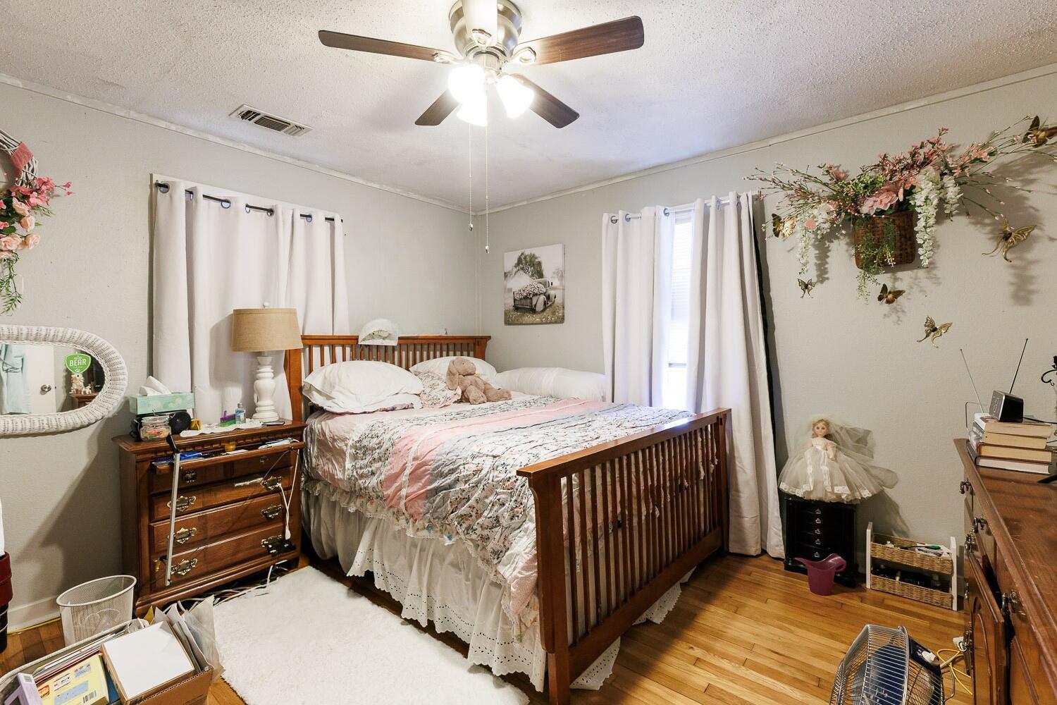 2004 26th Street Lubbock, TX 79411 - Photo 15 of 16 a bedroom with a bed and a chandelier
