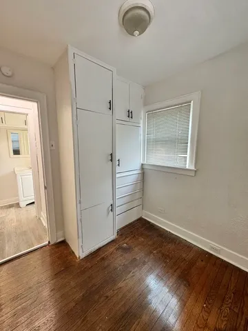 an empty room with wooden floor and a window