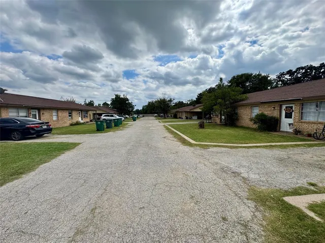 a view of a house with a big yard and a large trees