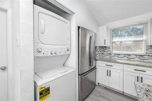 a kitchen with a refrigerator sink and cabinets