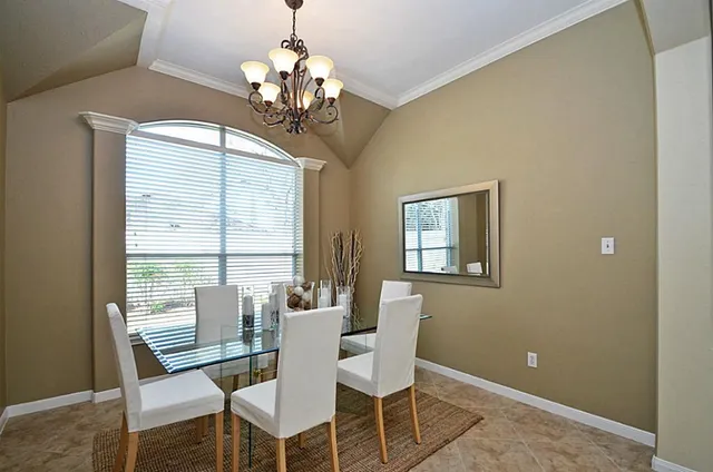 a view of a dining room with furniture a chandelier and wooden floor