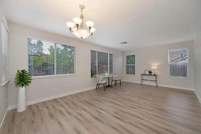 a view of a livingroom with wooden floor and a chandelier