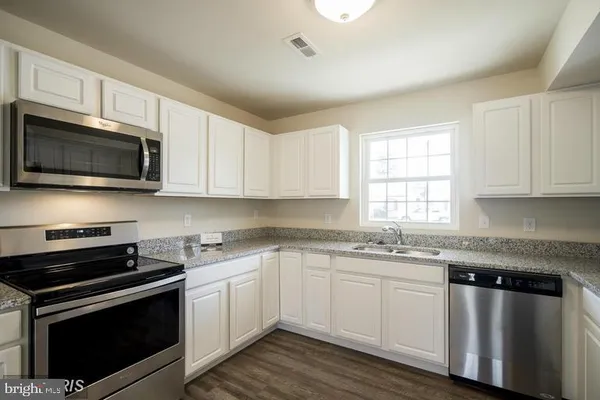 a kitchen with stainless steel appliances granite countertop a sink dishwasher a stove microwave and oven with cabinets