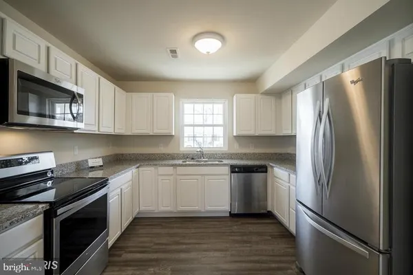 a kitchen with stainless steel appliances granite countertop a refrigerator sink and stove