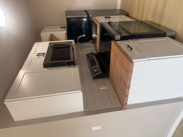 a kitchen with stainless steel appliances a stove a microwave a sink and cabinets