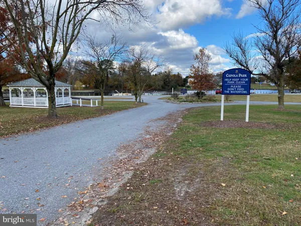 a sign that is sitting on a wooden bench in a yard