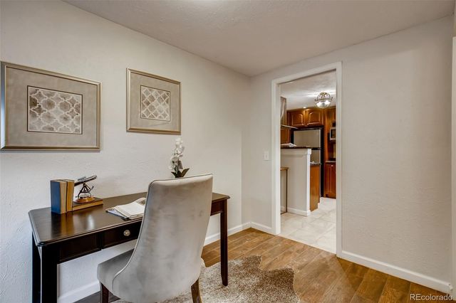a view of a workspace with furniture and wooden floor