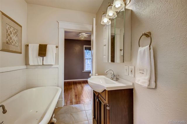 a bathroom with a tub sink and mirror