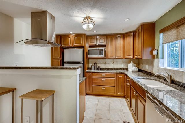 a kitchen with stainless steel appliances granite countertop a sink and a stove