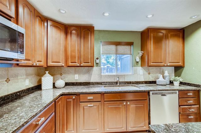 a kitchen with stainless steel appliances granite countertop a sink stove and cabinets