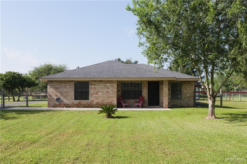 View of front of home featuring a front yard and a shingled roof