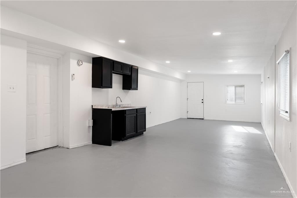 20538 Rio Rancho Road Harlingen, TX 78552 - Photo 11 of 19 Kitchen with dark cabinets, recessed lighting, light countertops, and concrete flooring