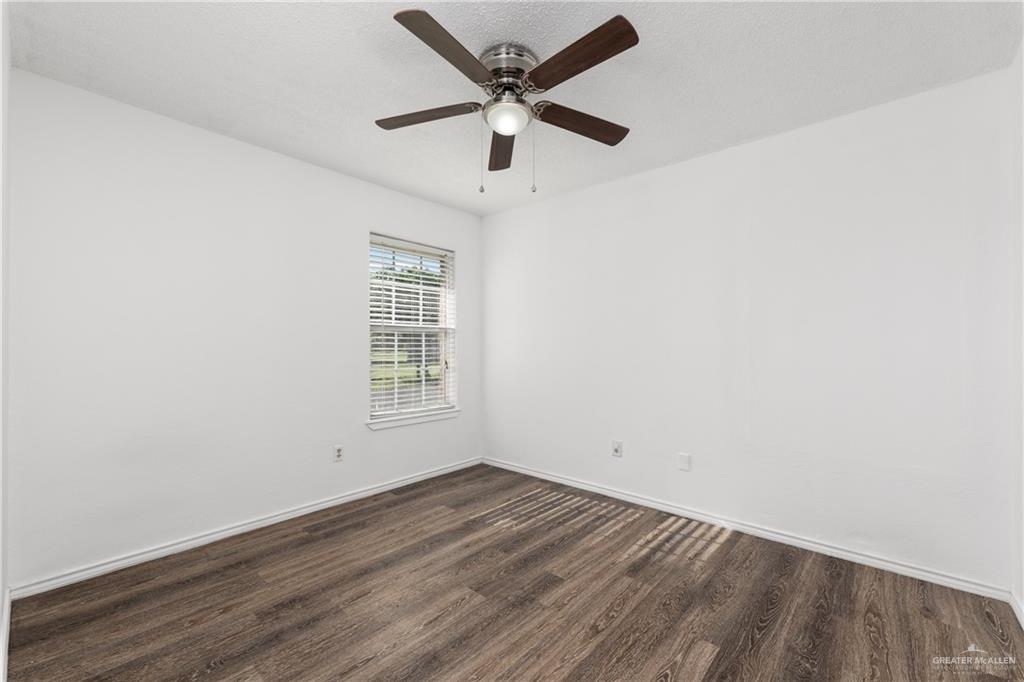 20538 Rio Rancho Road Harlingen, TX 78552 - Photo 8 of 19 Unfurnished room with dark wood finished floors and ceiling fan