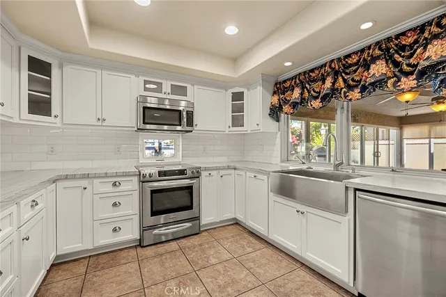 a large white kitchen with a lot of counter space and a sink