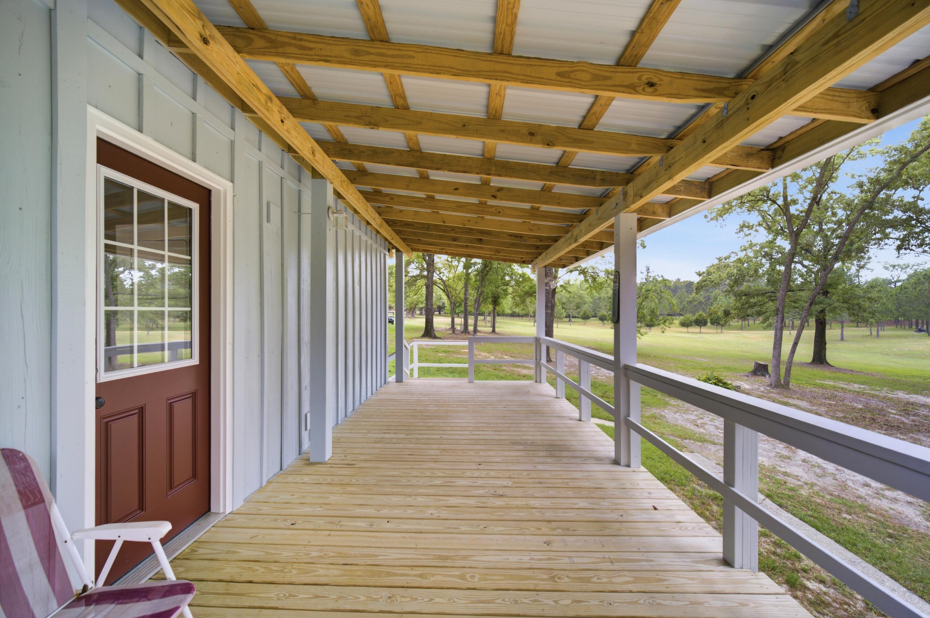 261 Wilkerson Road DeFuniak Springs, FL 32433 - Photo 67 of 76 a view of a porch with wooden floor and outdoor space
