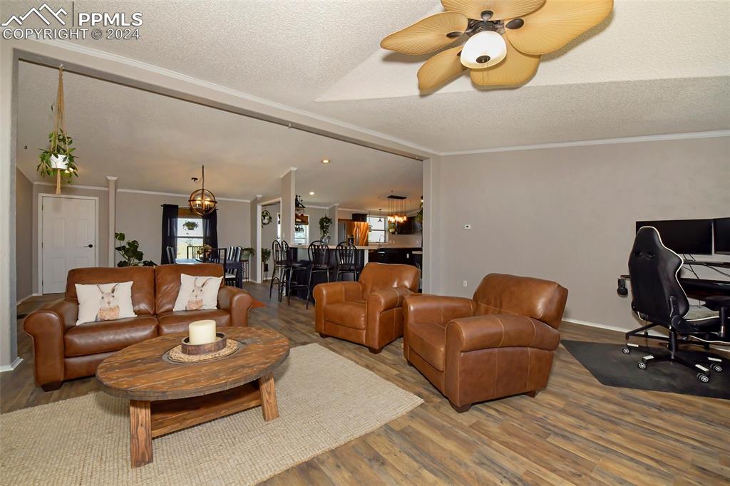 3975 Feather Ridge Drive Peyton, CO 80831 - Photo 19 of 36 a living room with furniture a rug and a chandelier