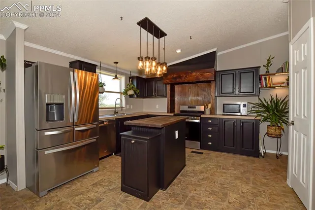 a kitchen with stainless steel appliances granite countertop a refrigerator a stove top oven a sink and dishwasher