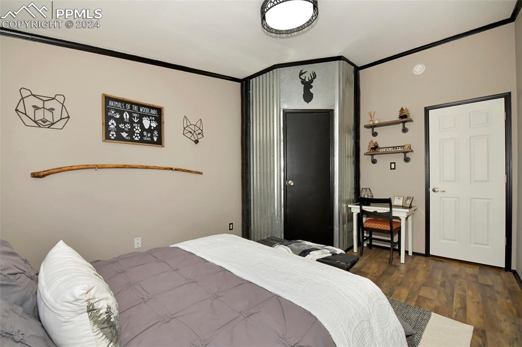 3975 Feather Ridge Drive Peyton, CO 80831 - Photo 33 of 36 a bedroom with a large bed and a chandelier