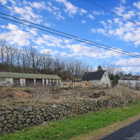 a view of house with yard and sitting area