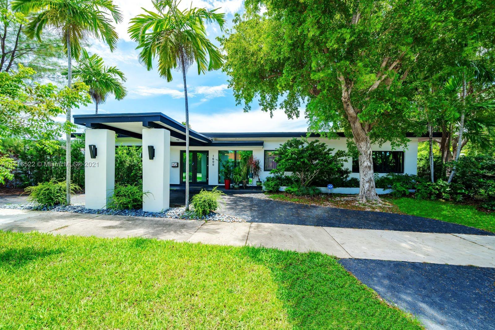 a view of a house with a yard and tree s