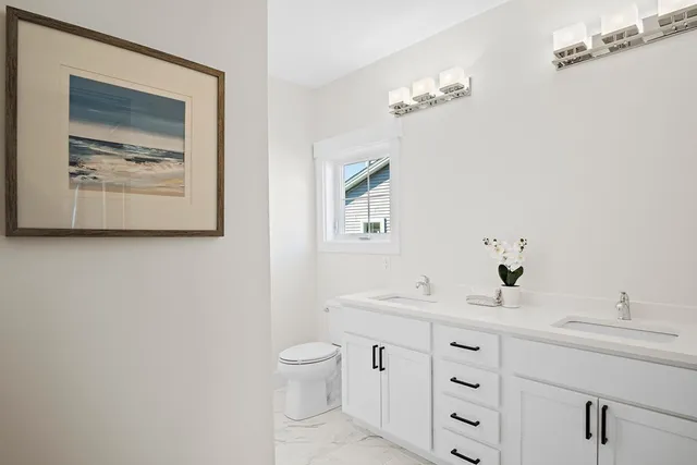 a bathroom with a toilet a sink and mirror